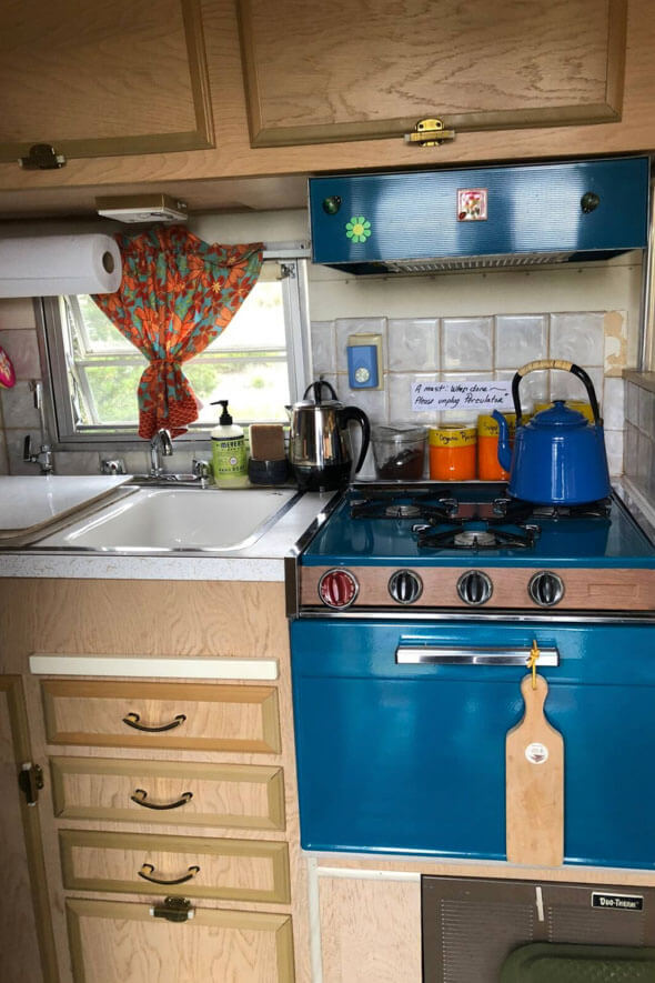 The cute kitchen inside the Lucy Desi Airstream features a stove and a sink