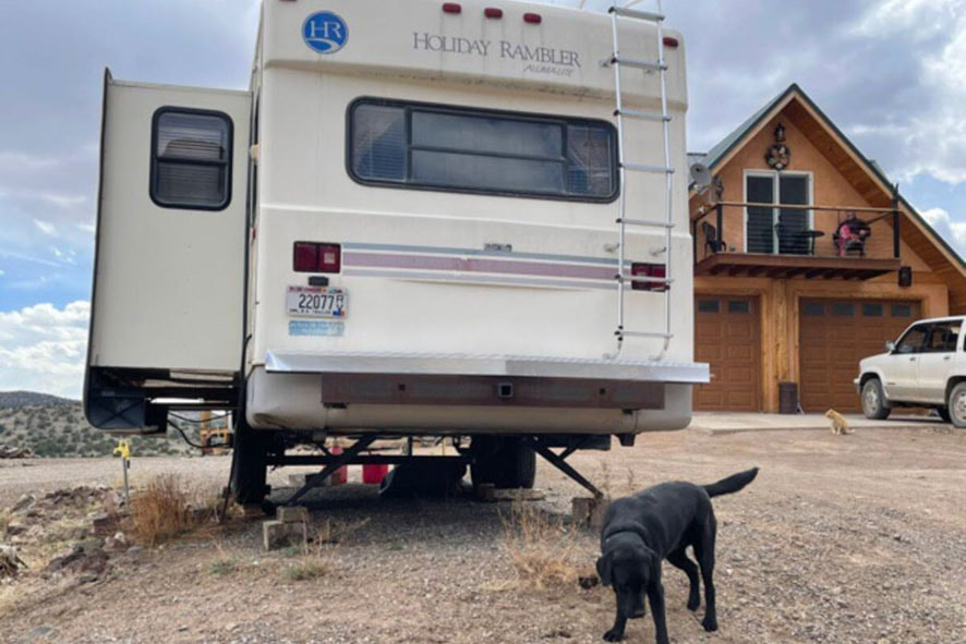 A black dog chilling by The Divide Rider's R&R Haven RV