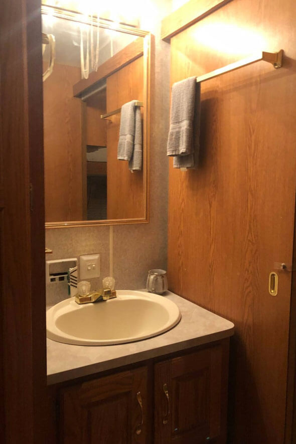 A convenient bathroom setup in the fifth wheel RV, featuring a sink and mirror