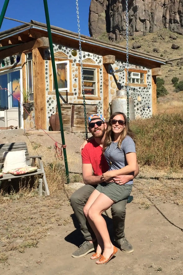 A romantic couple enjoying a swing in front of a tiny house