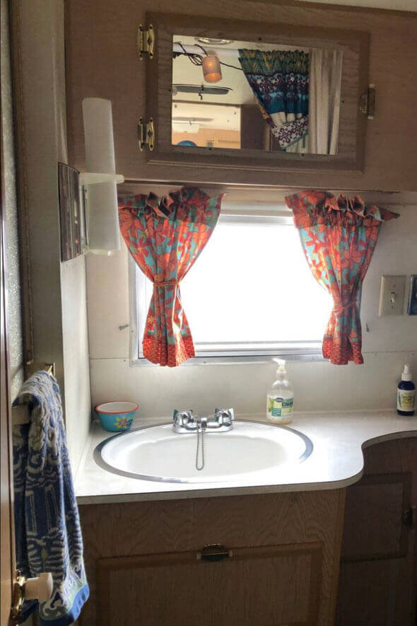 A compact bathroom featuring a sink and mirror