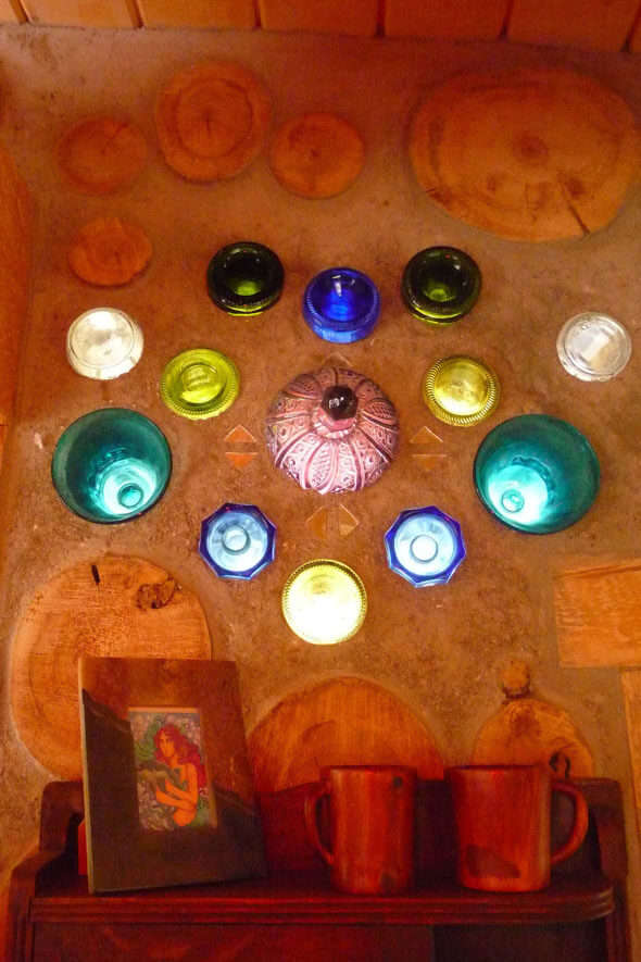 A vibrant display of assorted glass bottles adorning a wall, each bursting with a kaleidoscope of colors